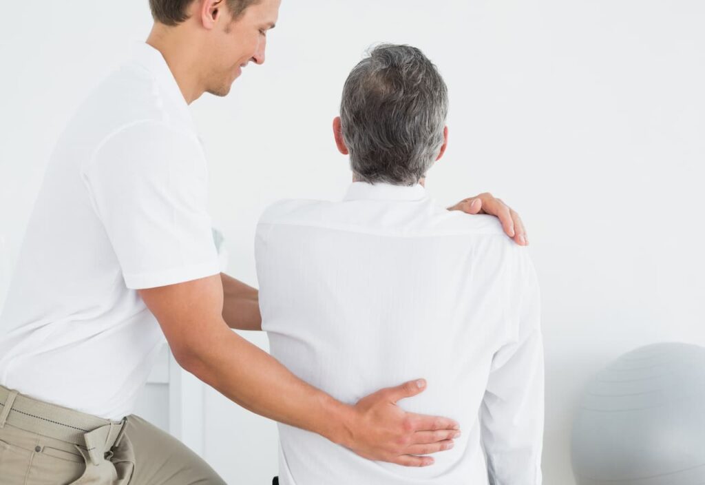 Thumbnail-For-Male-Chiropractor-Examining-Man-Back-By-Tisols Chiropractic
